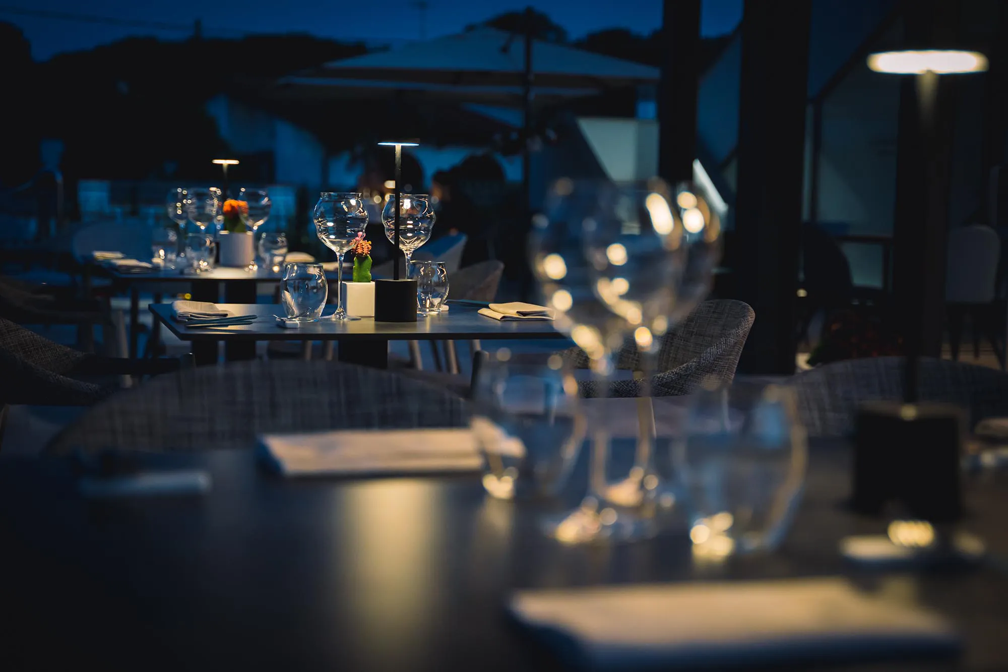 Nell'immagine alcuni tavolini del ristorante apparecchiati per la sera.